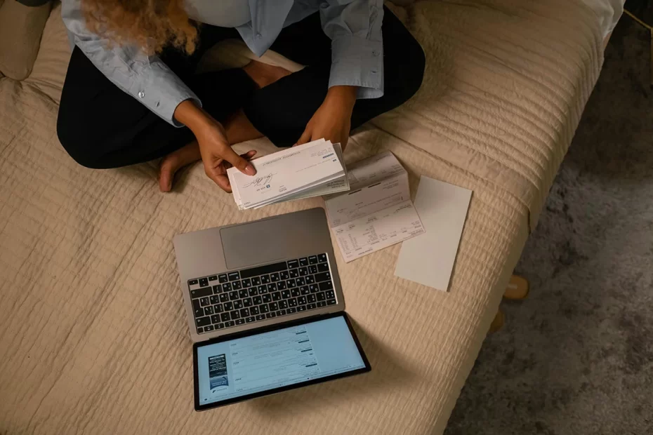Overhead view of woman with laptop and checks in her hand